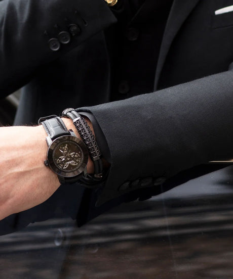 Man wearing the white gold-coated bracelet featuring a large centerpiece set with 37 diamonds and a black rubber band.