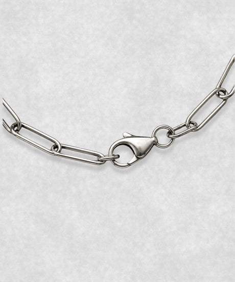 Close-up of 925 sterling silver paperclip bracelet clasp – polished elongated link chain detail