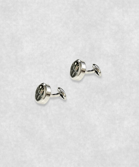 Side view of chrome-plated tourbillon cufflinks – luxury watch-inspired design with moving flywheel and blue screw details